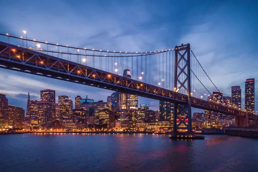 Le Bay Bridge et le front de mer d'Embarcardero sont illuminés la nuit.