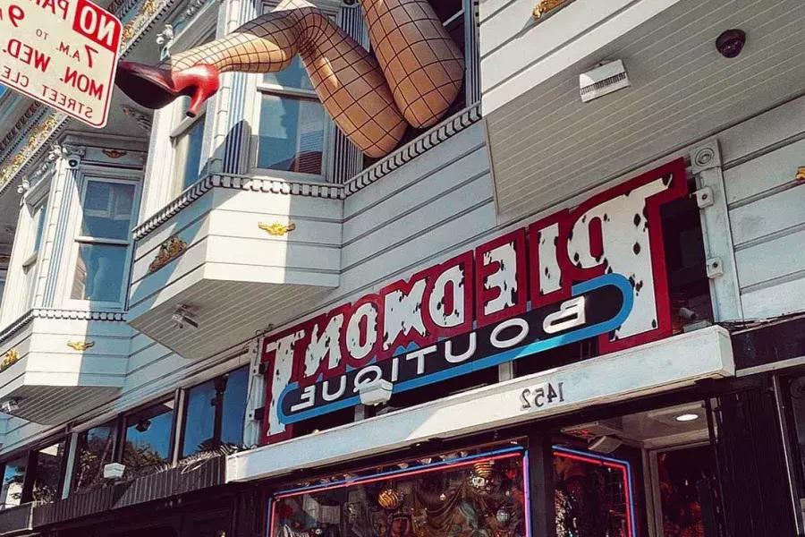 A pair of mannequin legs wearing fishnet stockings hang out of A window over Haight Street at Piedmont Boutique. 是贝博体彩app,california.