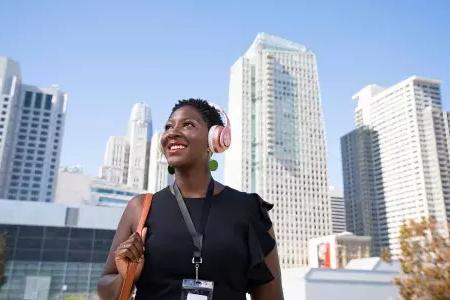 A woman wearing headphones walks through San Francisco's SoMa neighborhood.