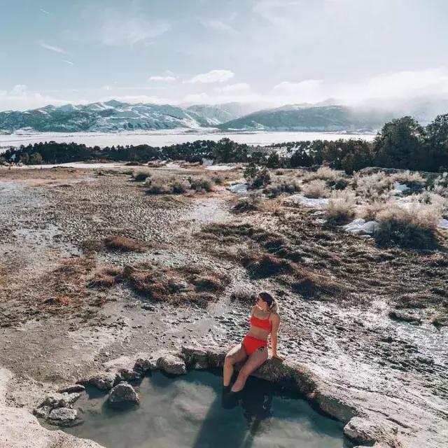 Uma mulher relaxa em fontes termais naturais além de 贝博体彩app.