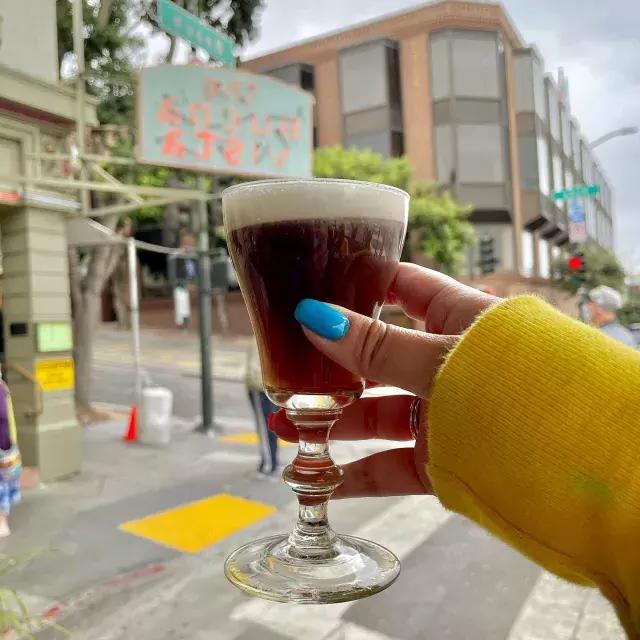 A visitor enjoys an Irish coffee outside the famous Buena Vista 咖啡馆